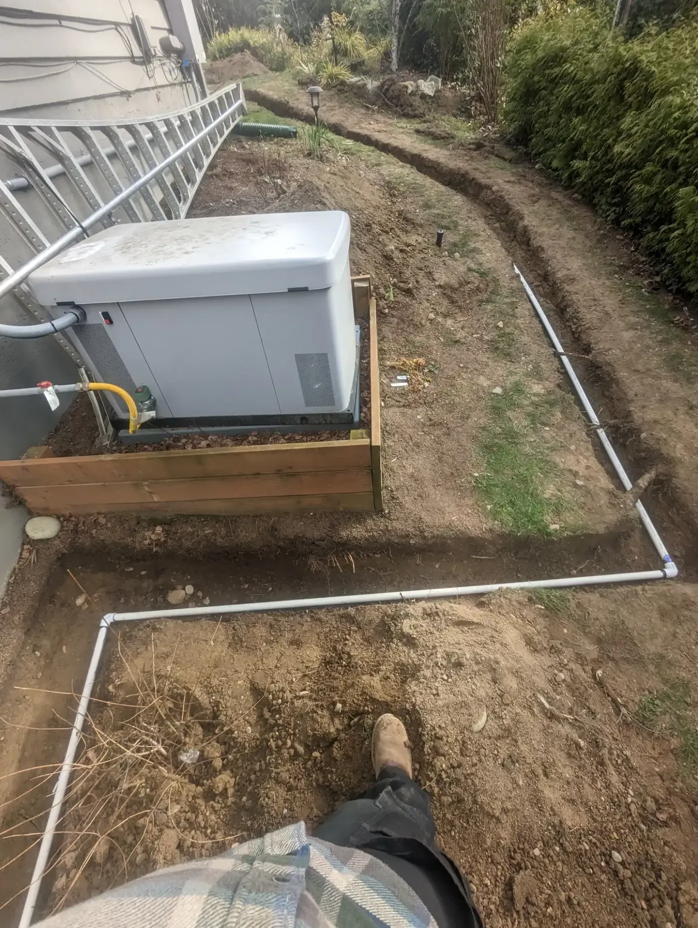 White PVC laid in fresh trenches beside generator on timber pad
