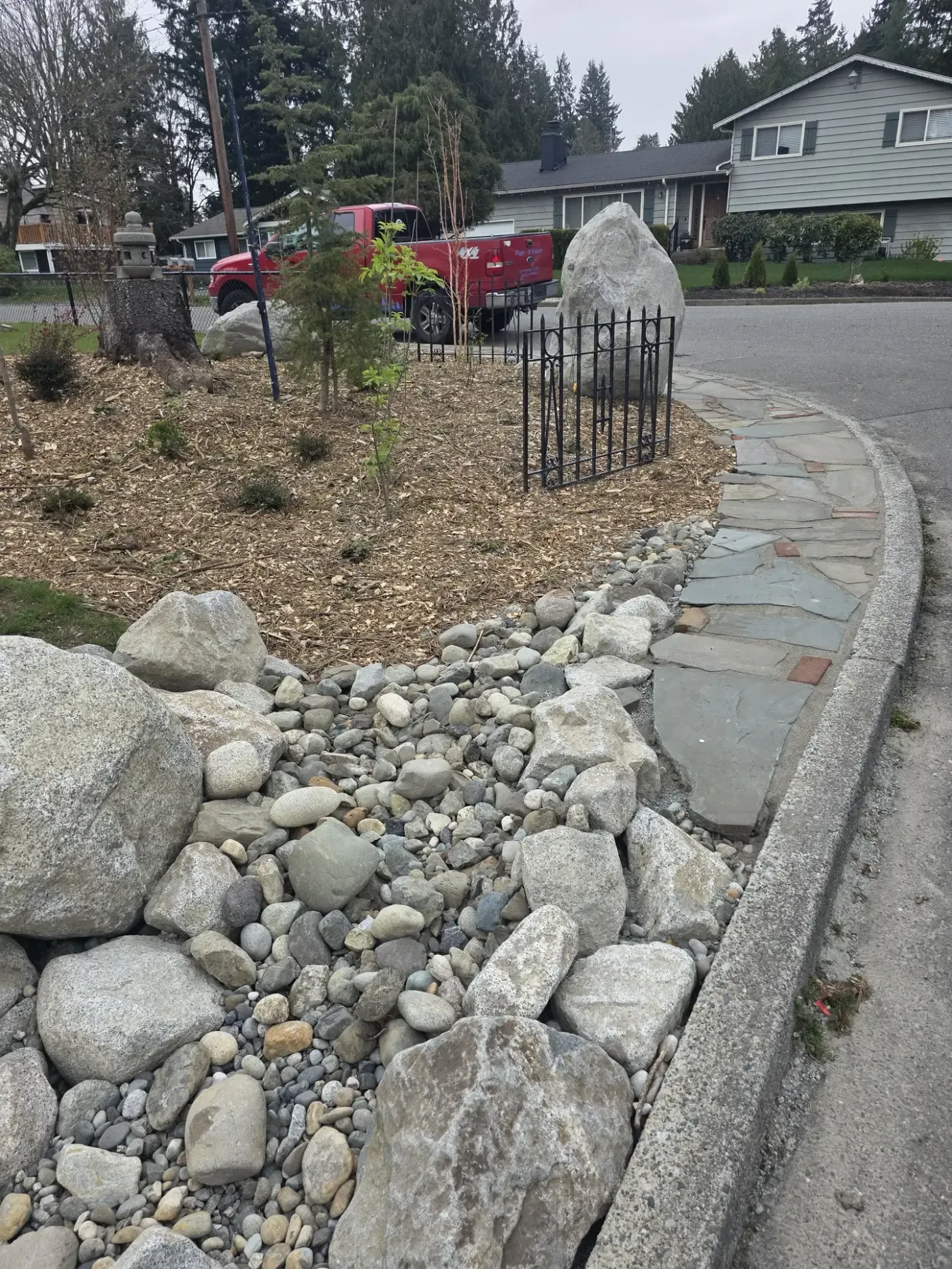 Cobble dry creek bed with boulders beside flagstone curb edge