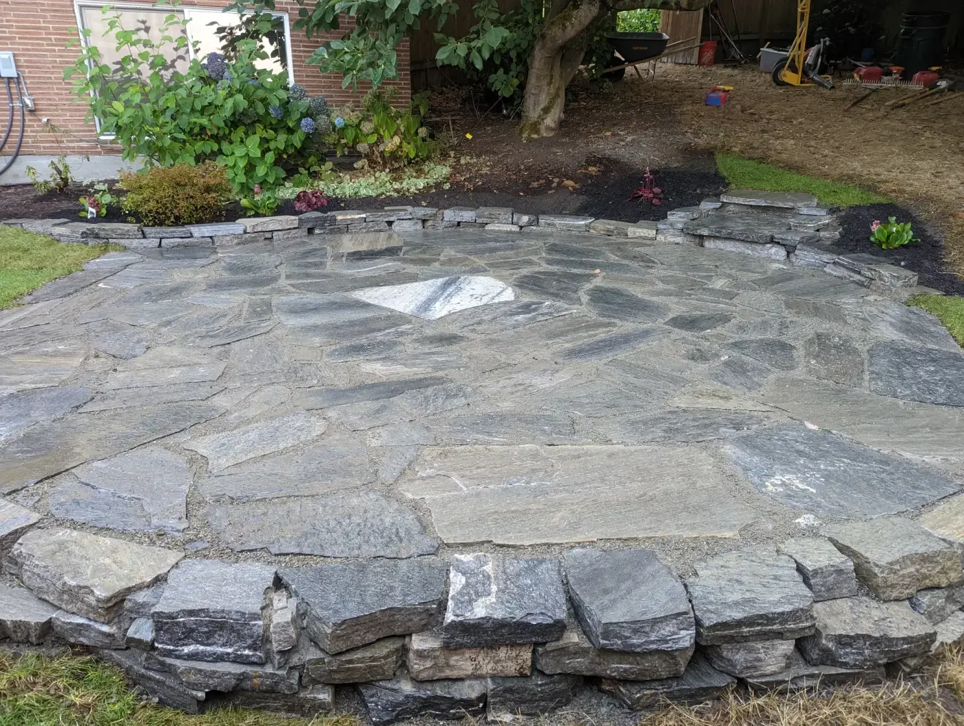 Close view of stone patio edged with dry-stacked stone course