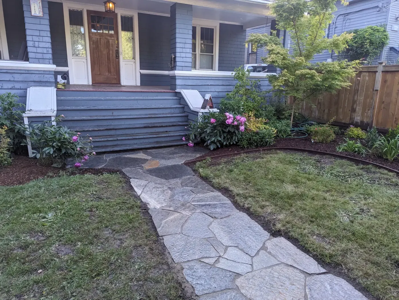 Grey flagstone front walk leading to craftsman porch steps