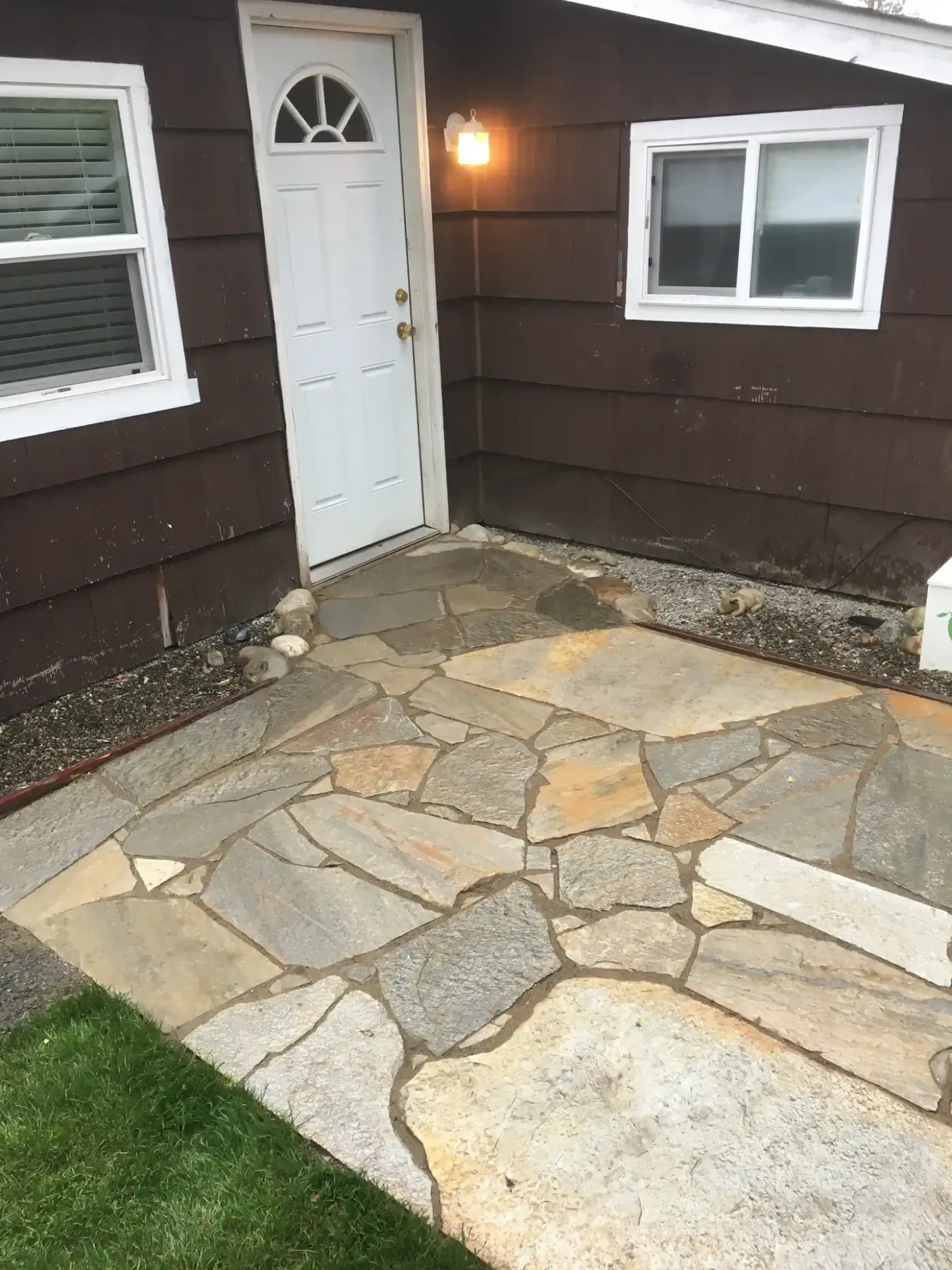 Closer view of mortar-jointed flagstone landing outside white door