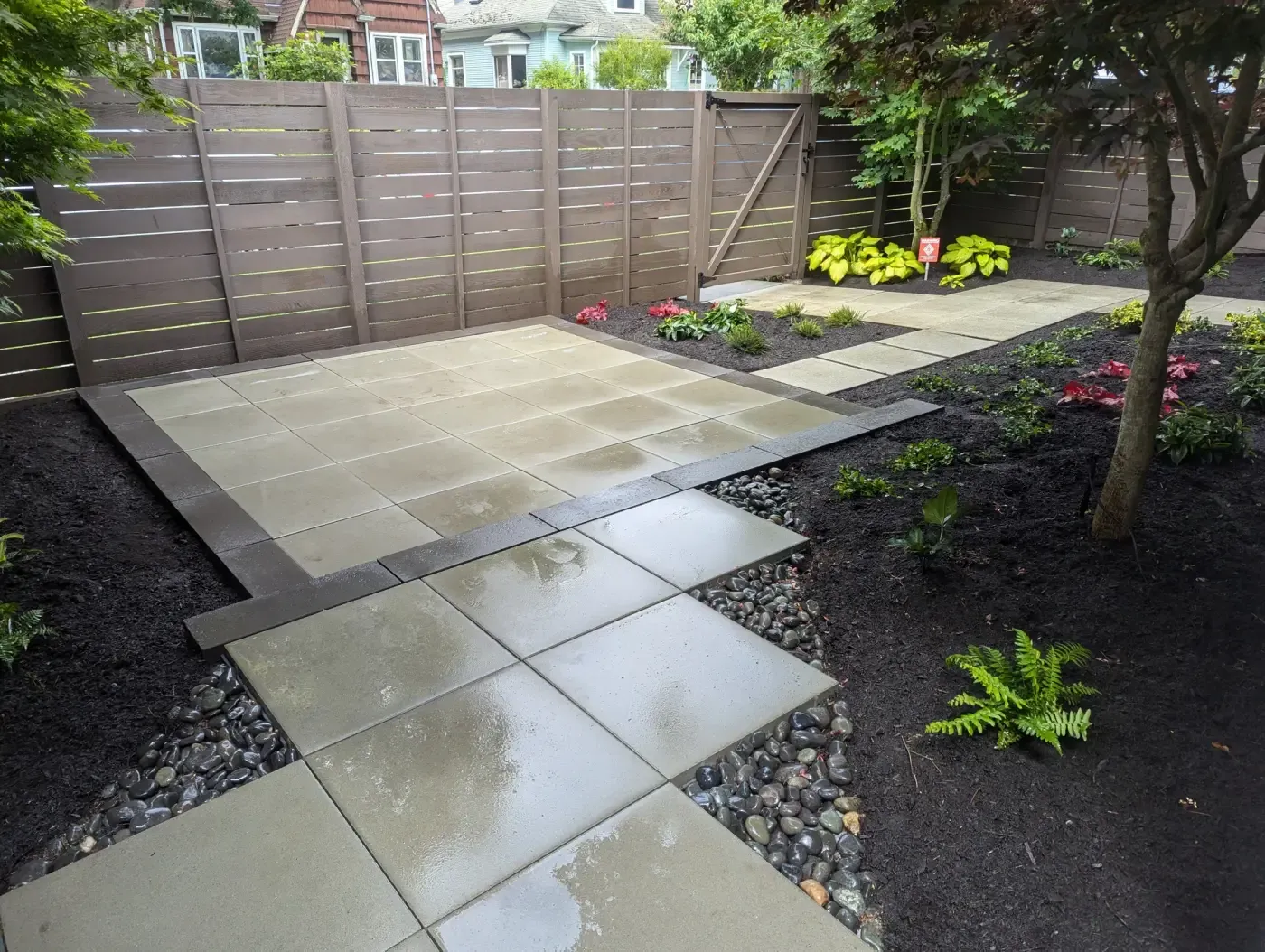 Square slab patio and stepping pads set in washed river rock
