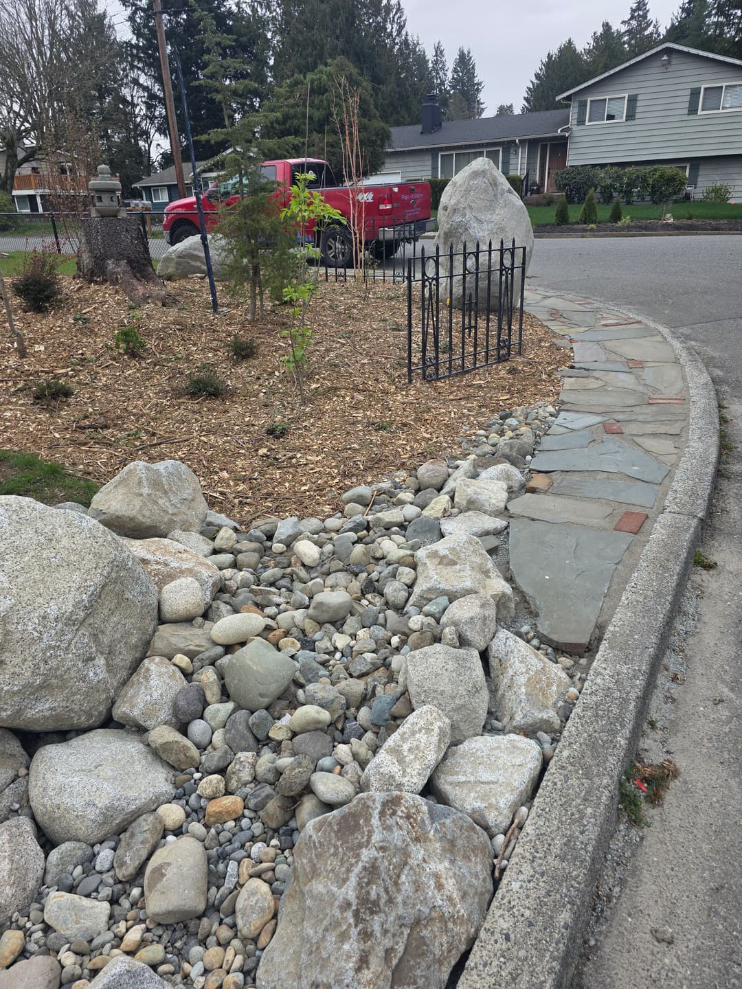 Landscaped garden with rocks, pebbles, and flagstone path