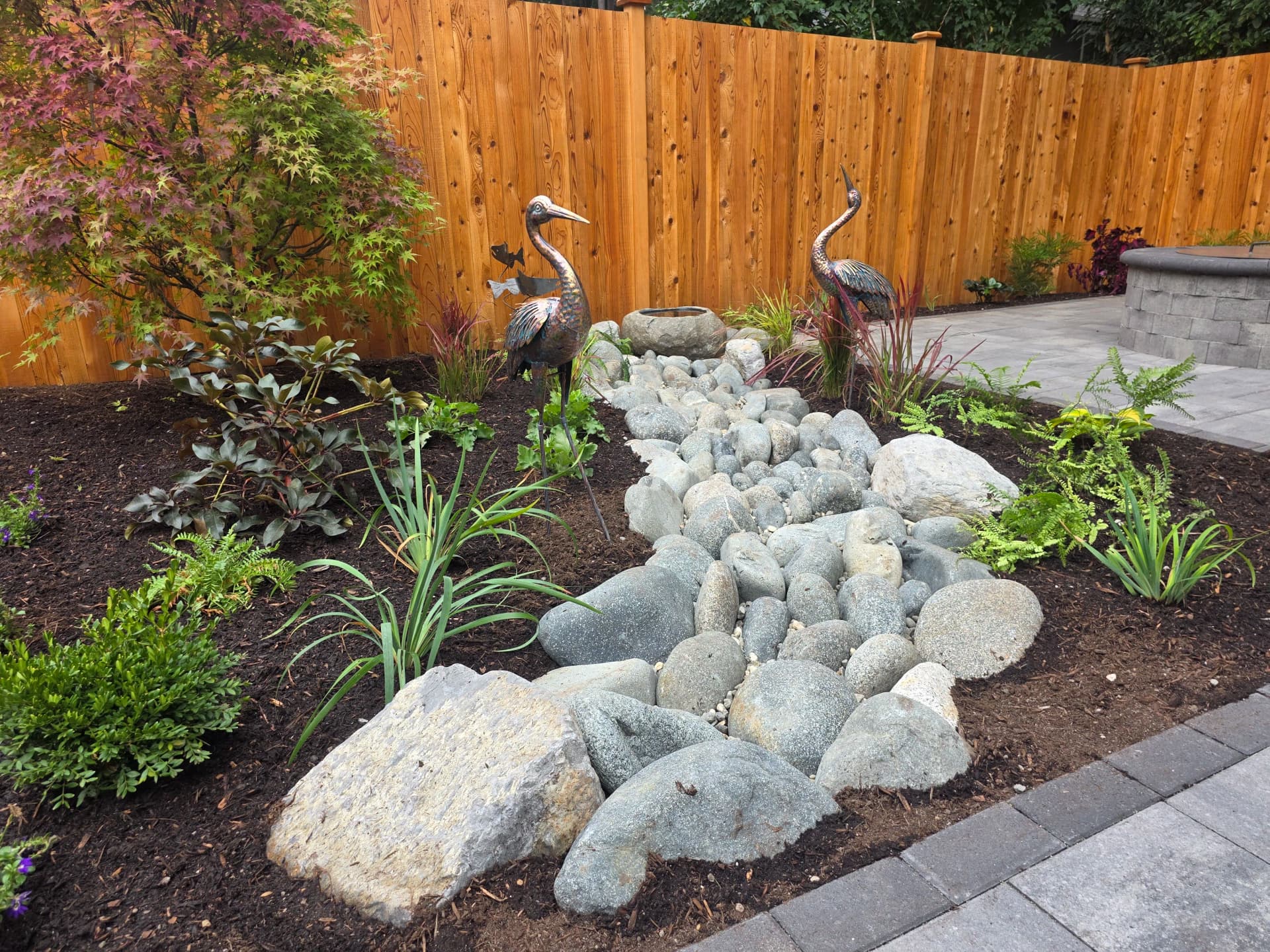 Backyard Refresh With River Rock, Pavers, and Custom Plantings image